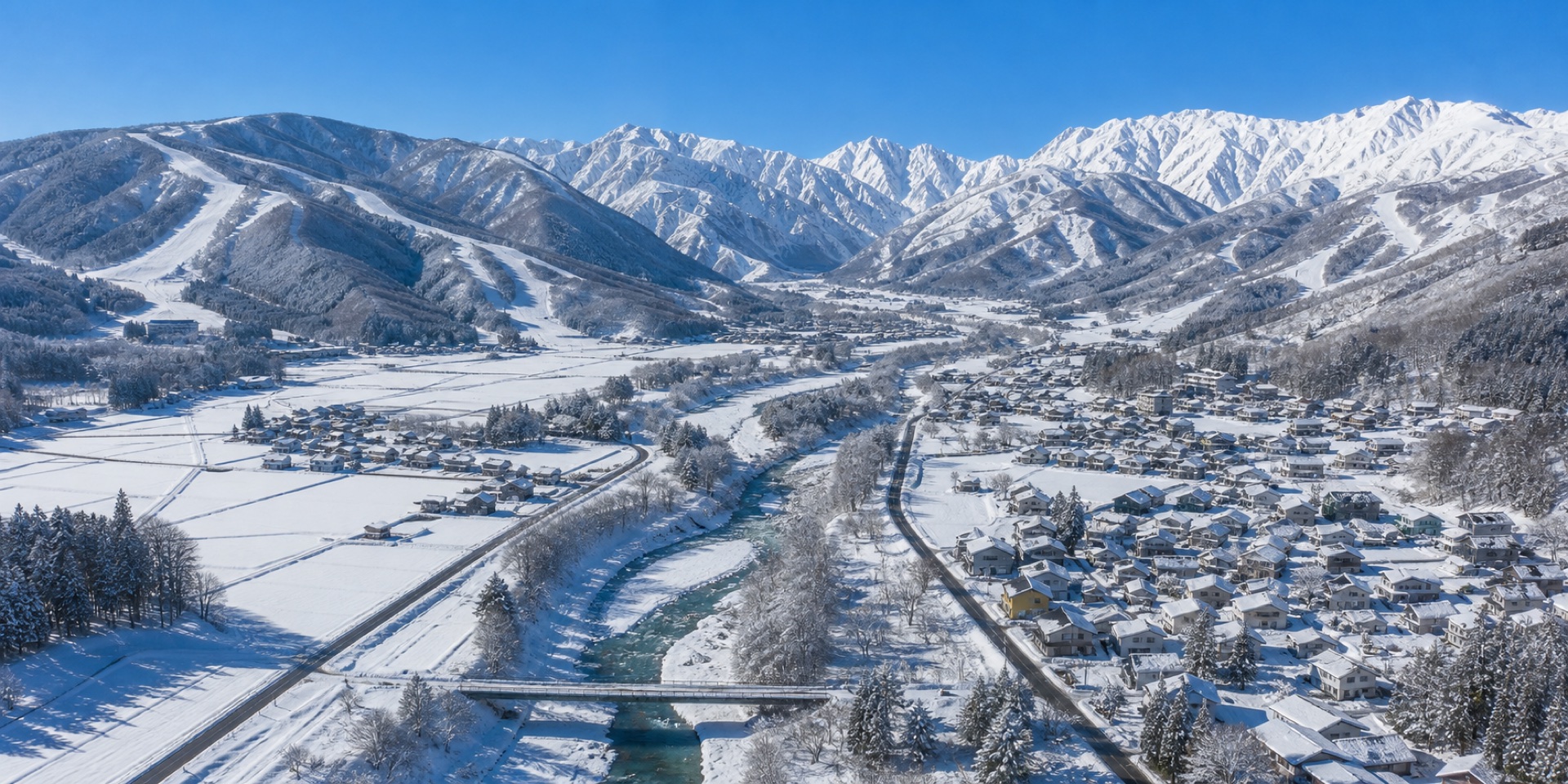 Aerial view along the snowy Hakuba Valley with the Himekawa river, villages and ski areas